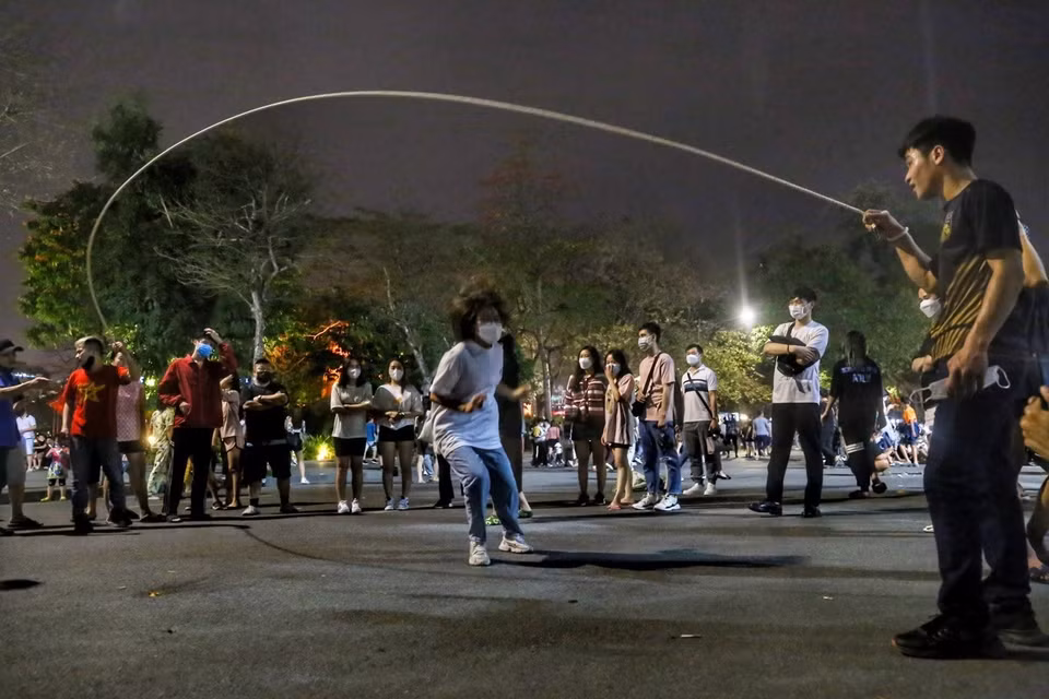 在还剑湖步行街区，年轻人欢乐地参加民间游戏。图自越通社