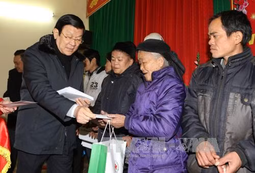 张晋创主席向禄平边境县的姆山、秀幂、安快等三乡居民赠送礼物。（图片来源：越通社）
