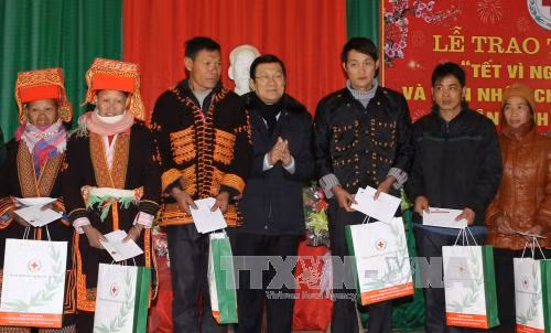 张晋创主席向禄平边境县的姆山、秀幂、安快等三乡居民赠送礼物。（图片来源：越通社）