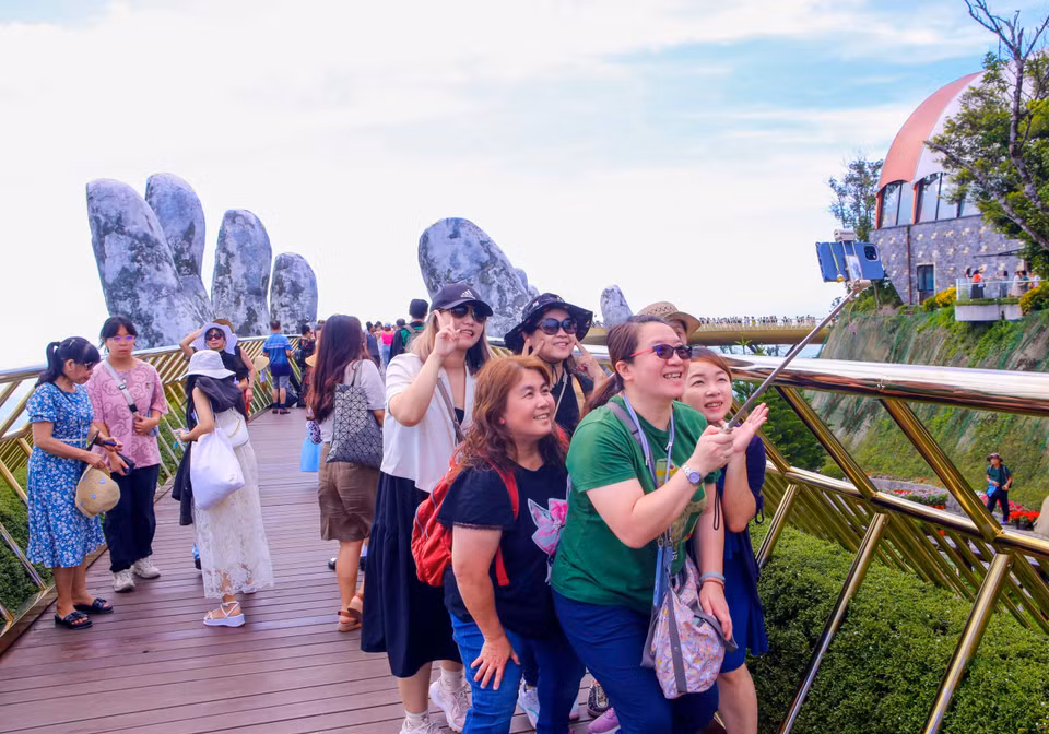 游客在巴拿山太阳世界旅游度假区金桥上拍摄打卡。图自越通社