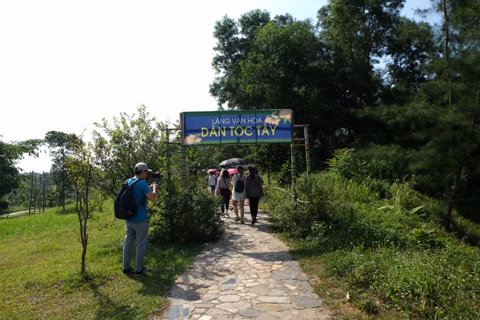 游客们参观岱依族文化村。图自越通社