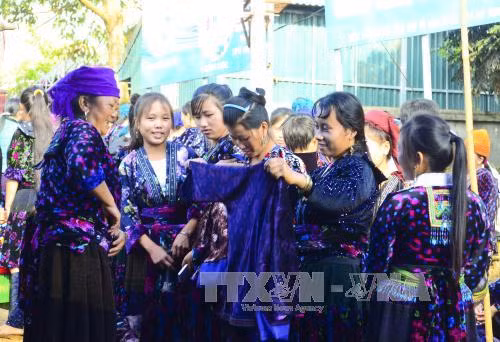 在舍雅​集市挑选衣服准备迎春的少数民族少女（图片来源：越通社）​