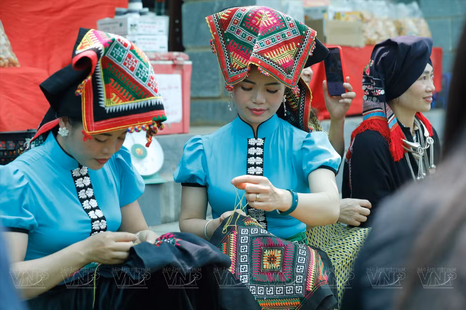 游客探索傣族同胞的服装缝纫技巧。图自 越通社/越南画报