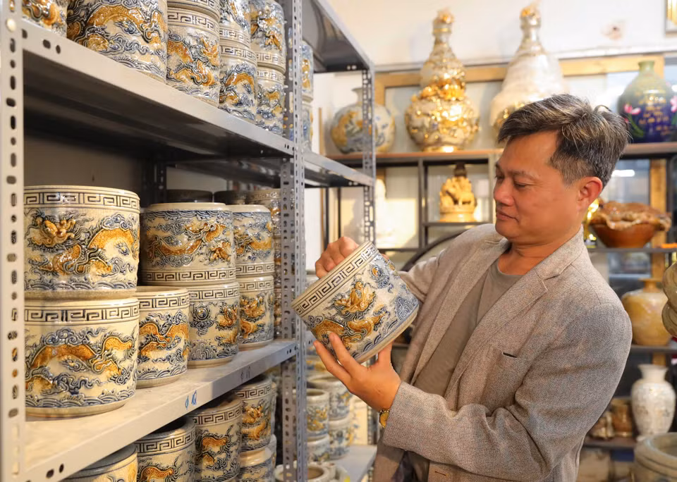 顾客在钵场陶瓷村选购龙凤香炉。图自越通社