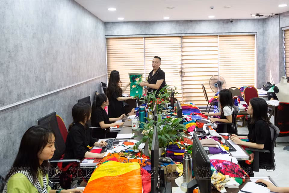 设计师杜郑淮南向员工传授奥黛设计和缝纫技术。图自越南画报