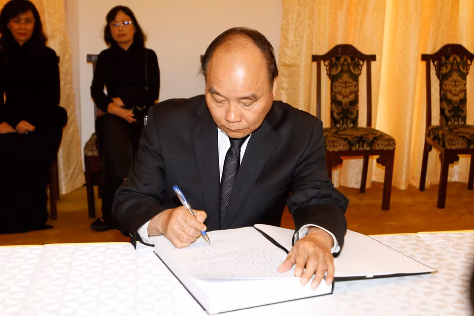 政府总理阮春福在吊唁簿上留言。（图片来源：越通社）