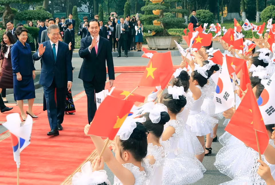 首都河内儿童手挥着国旗欢迎大韩民国总统文在寅和夫人。越通社记者 颜创 摄