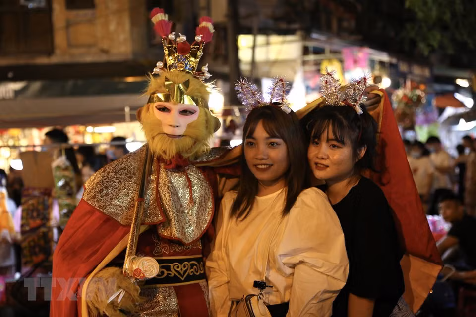 年轻人与“齐天大圣”合影留念。越通社记者 黄孝 摄
