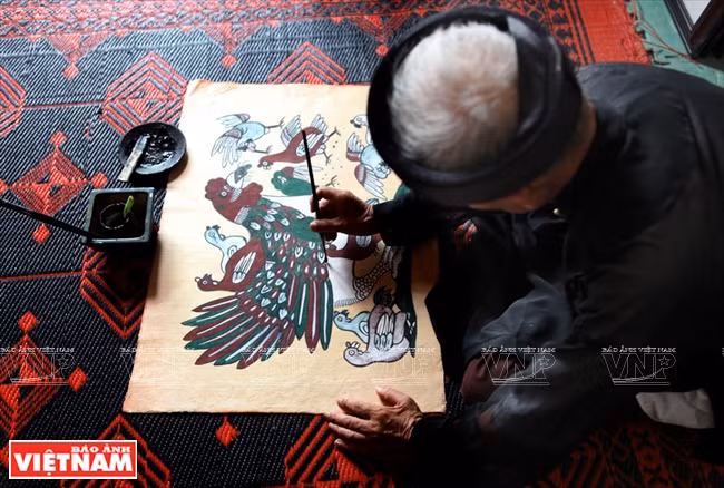 北宁省顺成县东湖画村阮登制艺人在完善鸡画作品。北部人过年常以东湖民间版画装饰居室。