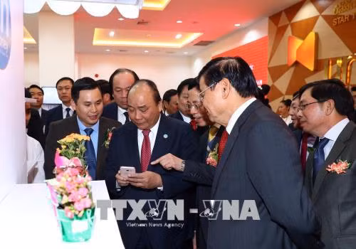越南政府总理阮春福与老挝政府总理通伦·西苏里走访参观老挝星光电信公司。越通社记者 统一 摄