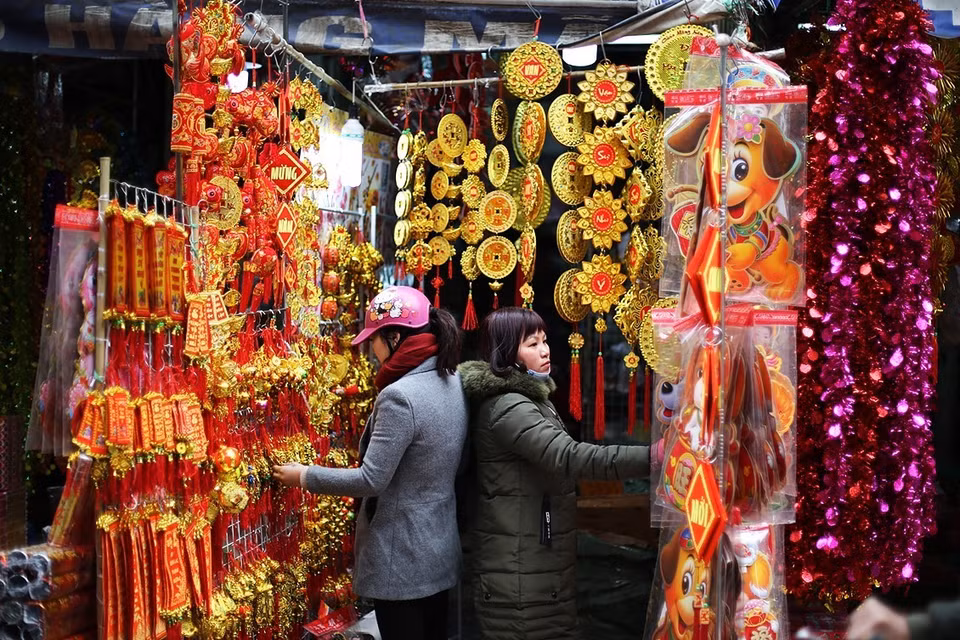 河内市马行街代卖供奉灶王爷的用品，其中包括灶君、神灵衣服等冥品。（图片来源：越通社)