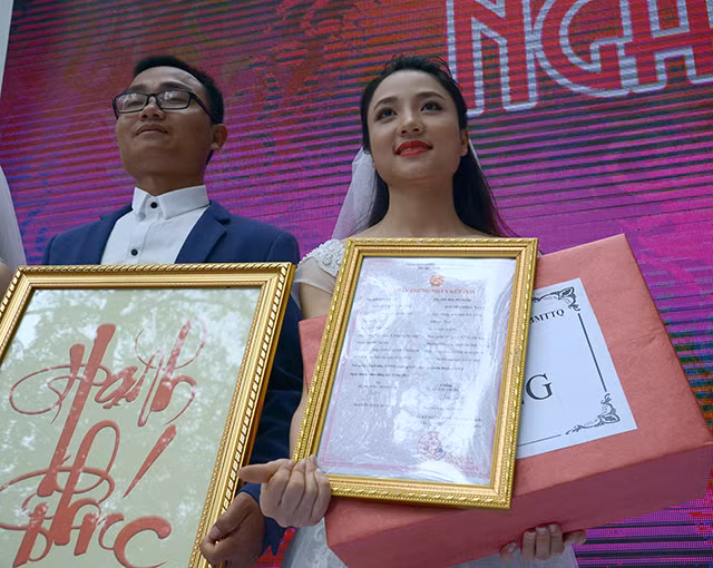 越南胡志明共青团河内团市委向每对夫妻颁发结婚证书并赠送结婚礼物。