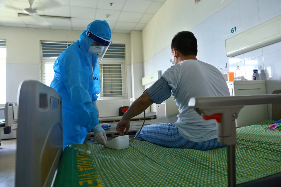 越南中央热带疾病医院东英县分院的医生对新冠肺炎确诊病例进行体检。图自 越通社