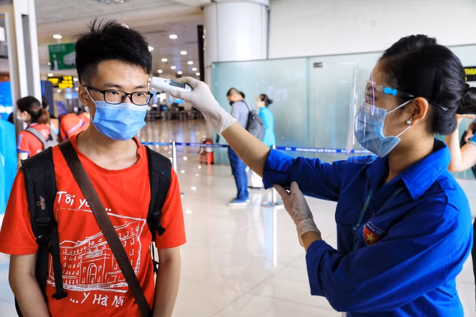上飞机前，内排机场人员为350名大学生和教师测量体温。越通社记者 成达 摄