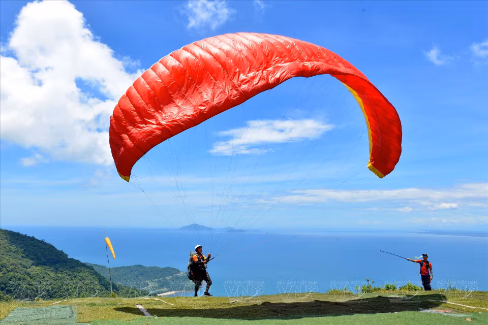 一名无发动机滑翔伞飞行员准备从海拔近 700米 的山茶山顶起飞。图自越南画报