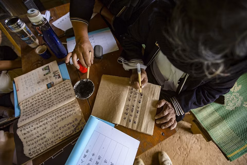 有空的时候，李文型先生勤奋地撰写前瑶族的字母。图自越通社