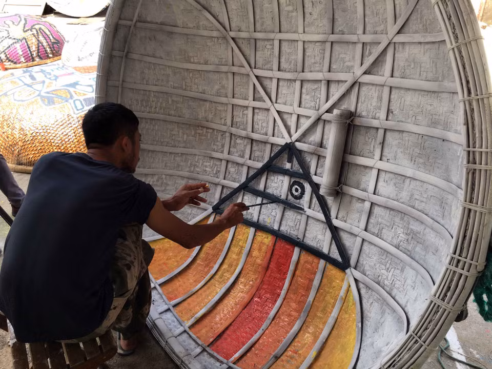 一名画家正在聚精会神地在竹篮船上创造艺术作品。越通社记者 杜长 摄 