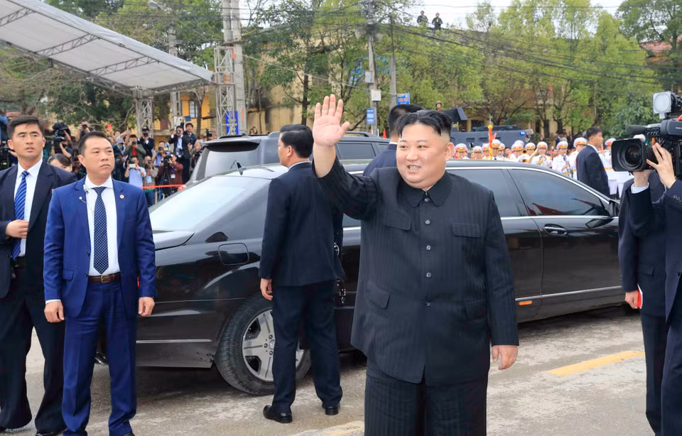 朝鲜最高领导人金正恩向在场群众挥手。图自越通社