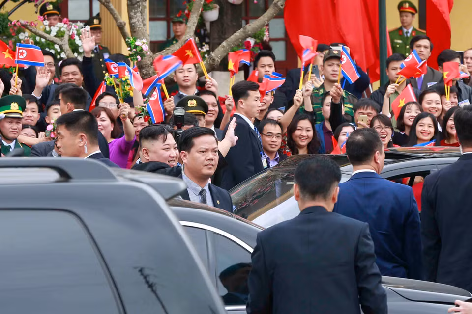 朝鲜最高领导人金正恩向在场群众挥手。图自越通社
