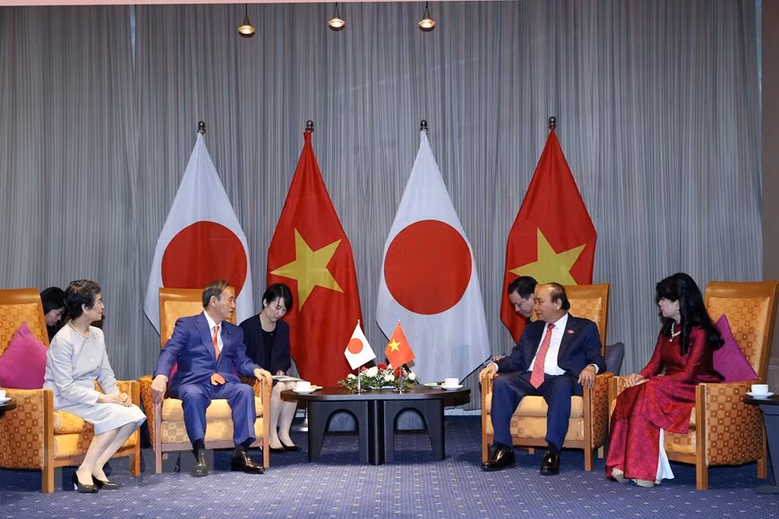 越南政府总理阮春福与日本首相菅义伟亲切交谈。图自越通社