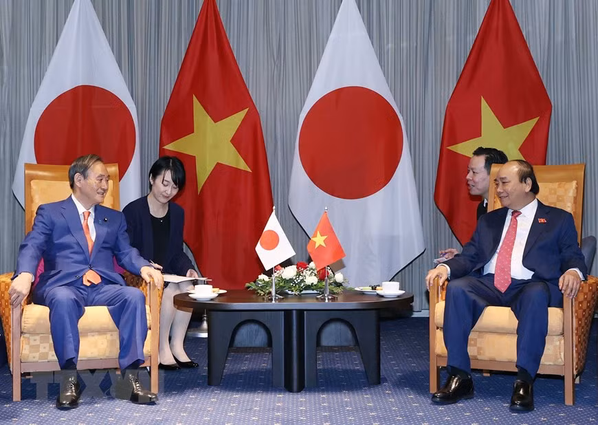 越南政府总理阮春福与日本首相菅义伟亲切交谈。图自越通社