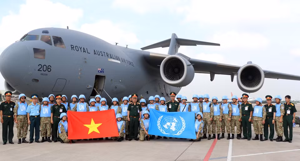 越南国防部副部长阮志咏上在一号二级野战医院的战士们登机前往南苏丹执行联合国维和任务前与他们合影。越通社发