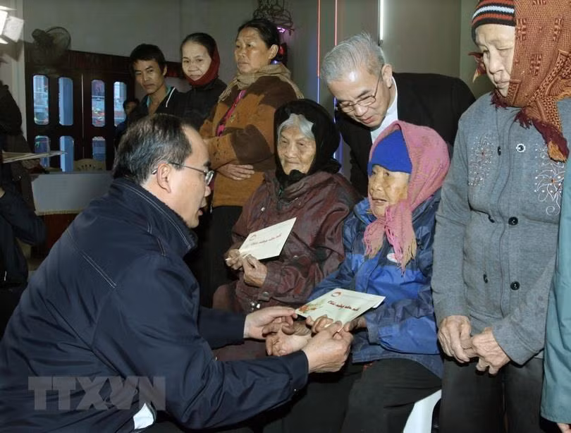 越南祖国阵线中央委员会主席阮善仁向清化省俄山县俄田乡田户教区的贫困信徒送上2015年乙末年纯洁慰问品。越通社发