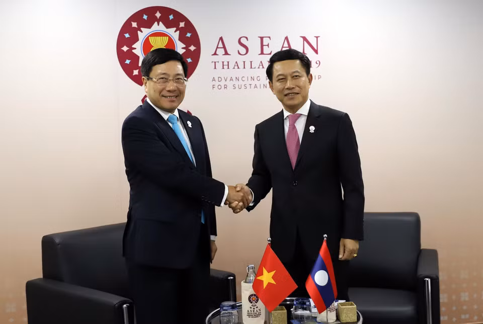 越南政府副总理兼外长范平明（左）2019年7月31日在泰国召开的第52届东盟外长会议间隙会见老挝外交部部长沙伦赛•贡玛希（Saleumxay Kommasith）。越通社发