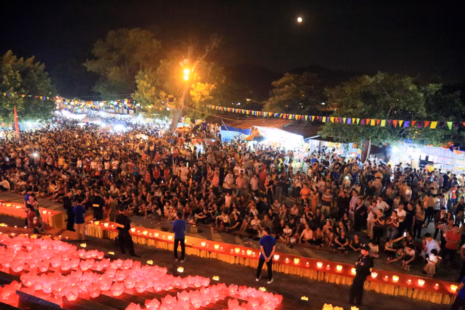 当地居民和来自四面八方的数千名游客一同参加祈安法会和放花灯活动。图自越通社