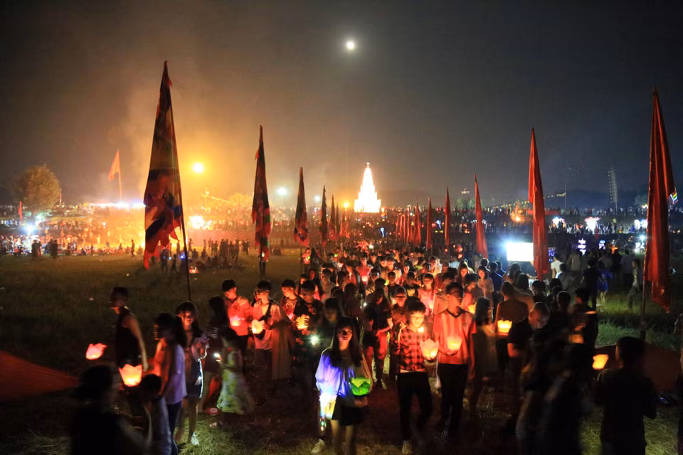当地居民和游客在六头江上放花灯。图自越通社