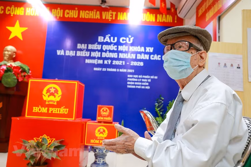 范文哥先生也是河内市各投票站最早投票的选民之一。 尽管年纪大，范文哥先生自 1946 年以来从未错过全国大选日。在全国选举日当天，选举组在进行投票前，必须宣读有关选举纪律，随后当着选民的面进行投票箱的验证、封箱，以确保公开性、客观性和人民监督的原则。这也是选民直接监督选举工作的一种方式。图自Vietnam+