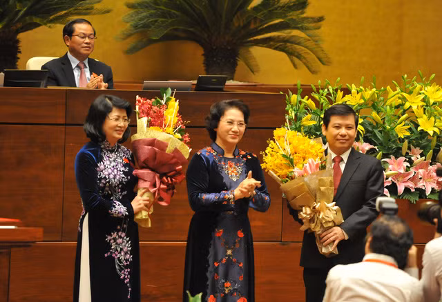 国会主席阮氏金银向新任国家副主席邓氏玉盛（左）和新任最高人民检察院检察长黎明志（右）赠送鲜花。