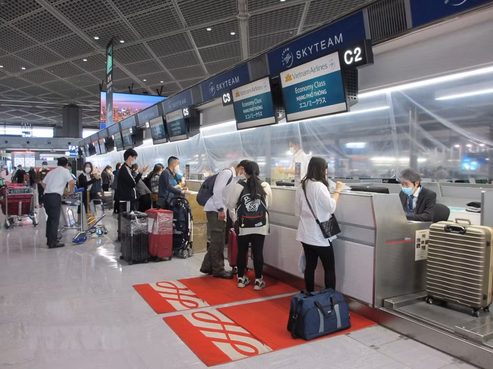 在成田机场的越南公民排队办手续。图自越通社