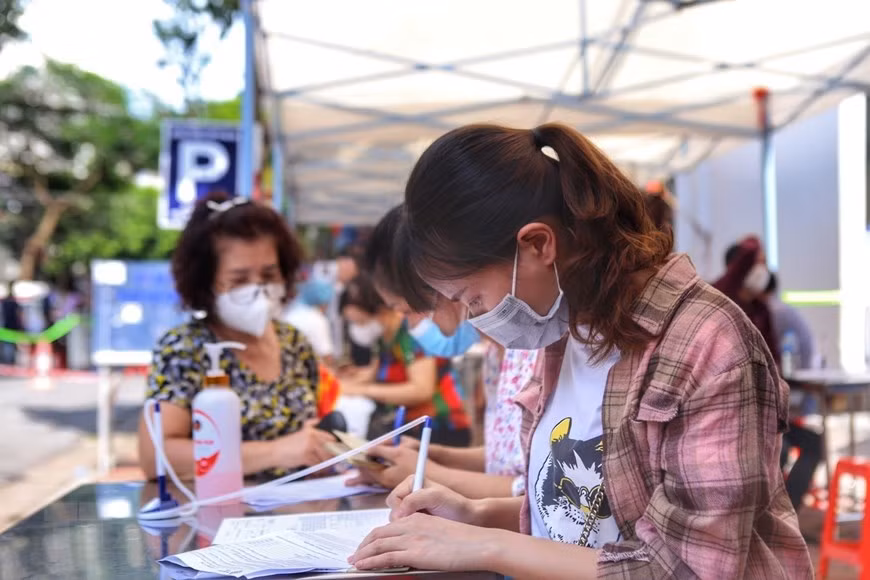 在河内综合医院接种点，二征夫人郡范廷虎坊人民在接种前都要进行健康申报。图自越通社