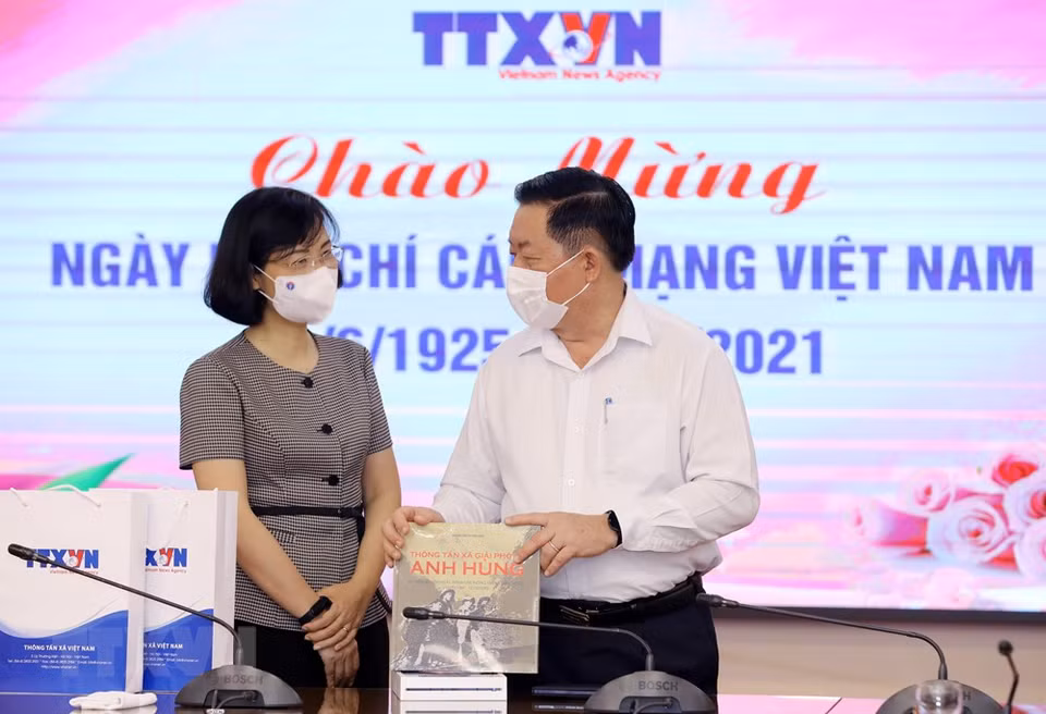 越通社副社长武越庄向中央宣教部部长阮仲义赠送越通社出版的书籍。图自越通社