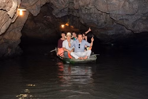游客乘船穿山而过，观赏溶洞。（图片来源：人民军队报）
