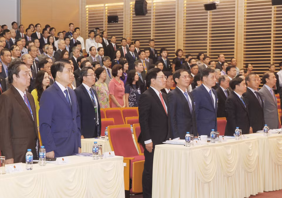 参会代表向国旗敬礼。越通社记者 林庆 摄
