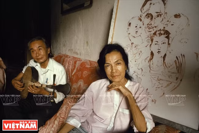 越南著名画家、雕塑家叶明珠（左）与《胡伯伯与中南北三部儿童》血画。凯萨琳‧卡诺 摄