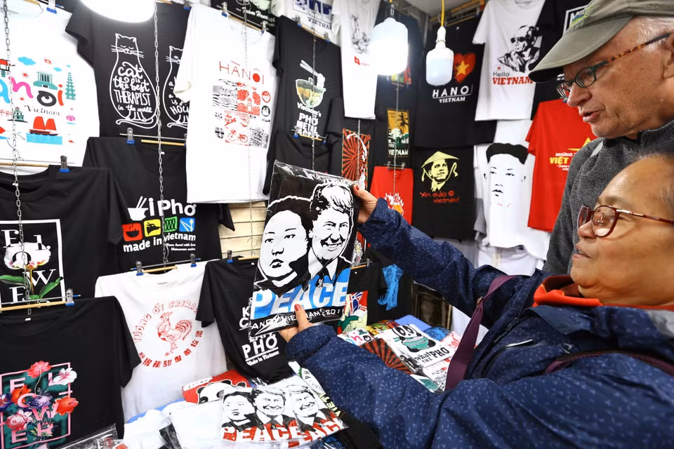 国际游客购买印有特朗普与金正恩图案的T恤。图自越通社