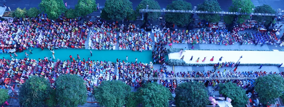 3月3日上午，3000多人在阮慧步行街一起穿着奥黛走秀。图自越通社