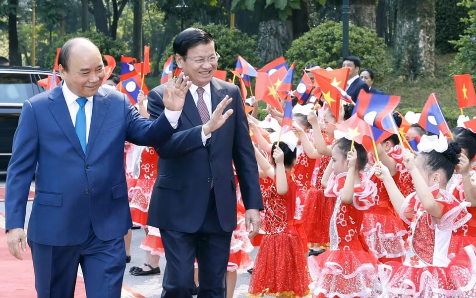 越南政府总理阮春福举行仪式 欢迎老挝政府总理通伦·西苏里访越。图为两位总理向儿童们挥手。越通社记者 统一 摄