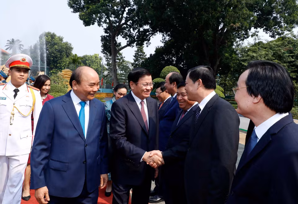 阮春福向通伦介绍越南政府代表团成员。越通社记者 统一 摄