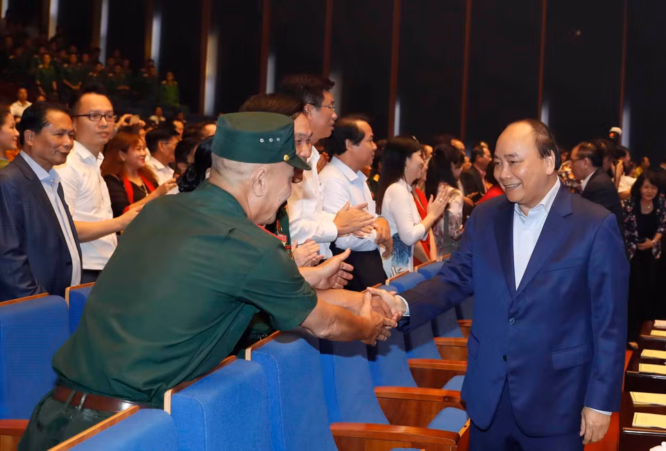 阮春福同与会代表握手。图自越通社