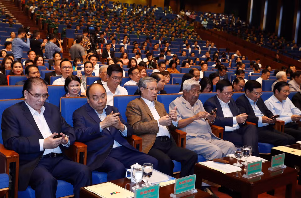 阮春福同与会代表发短信支持活动。图自越通社