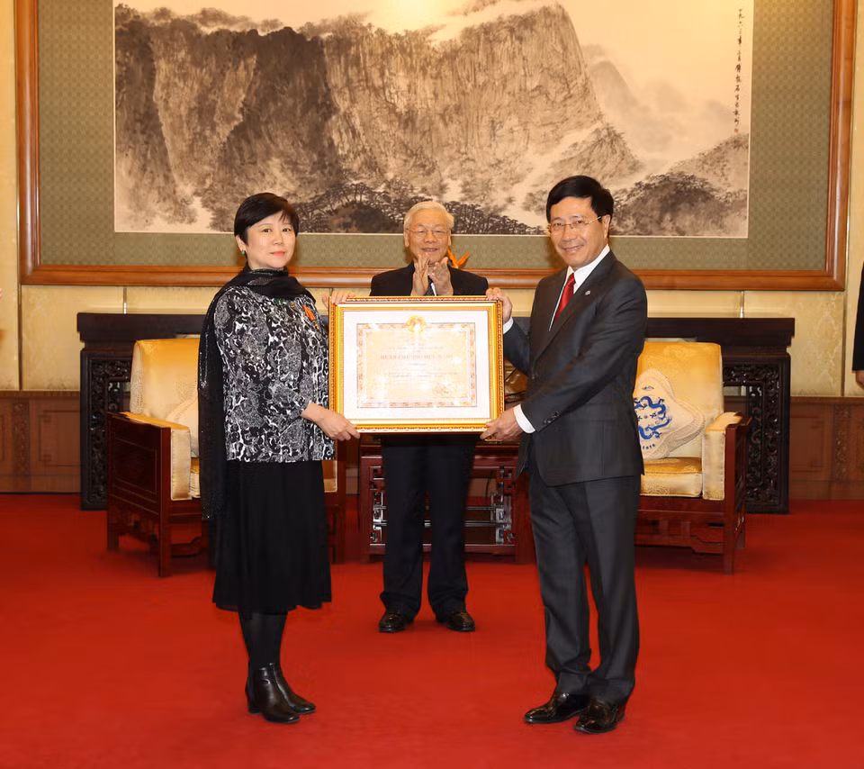 受越南国家主席的委托，政府副总理兼外长范平明向中国人民对外友好协会会长李小林女士授予友谊勋章。（图片来源：越通社）（图片来源：越通社）
