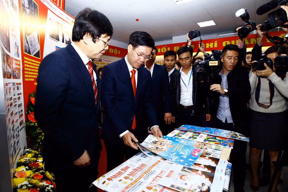 中央宣教部部长武文赏（中）参观2017年全国报刊展。（图片来源：越通社）