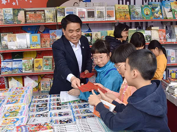 河内市人民委员会主席阮德钟给春节购书的小孩们派红包。(图片来源：越南《人民报》)