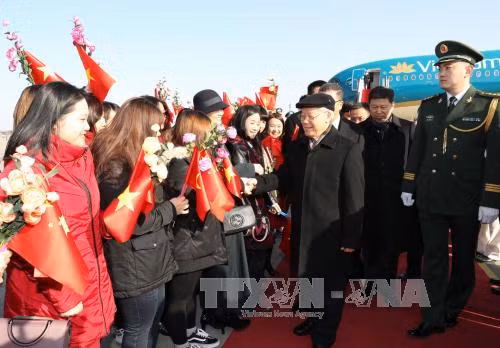 越南驻中国大使馆工作人员和旅​居中国越侨和越南人到机场迎接阮富仲一行。（图片来源：越通社）