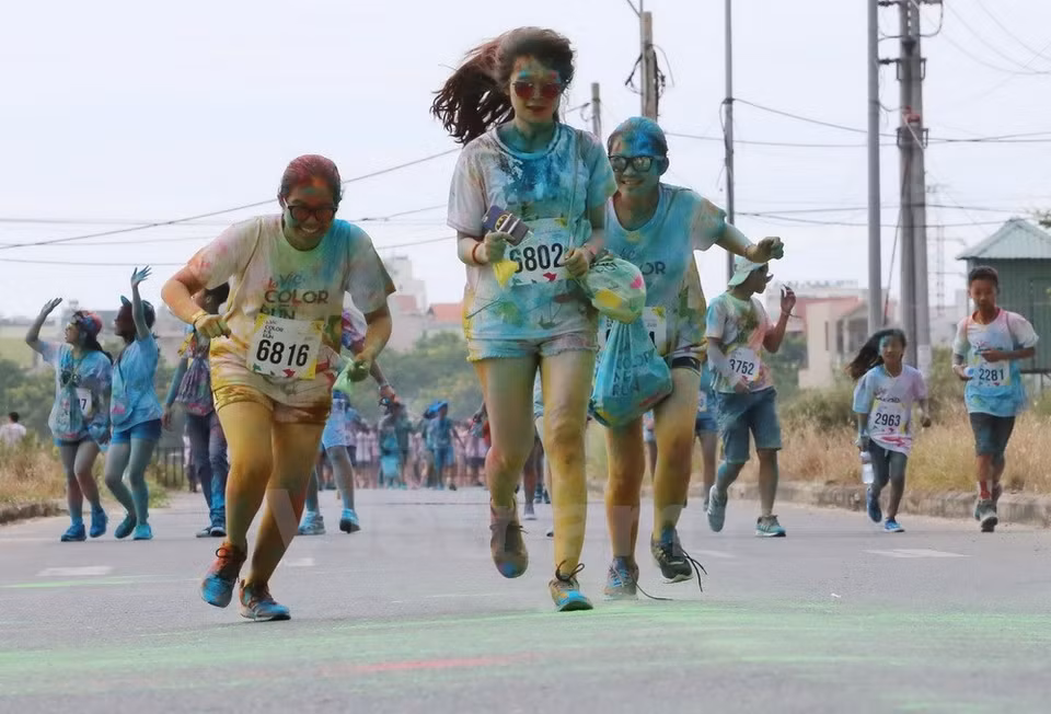6月25日在岘港市举行的“彩色跑——Color Me Run”活动。参观者从头到脚抛撒彩色粉末（图片来源：越通社）