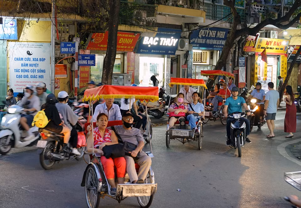 游客乘坐越式三轮车，参观游览河内古街。这已成为河内的一张旅游名片。图自越通社